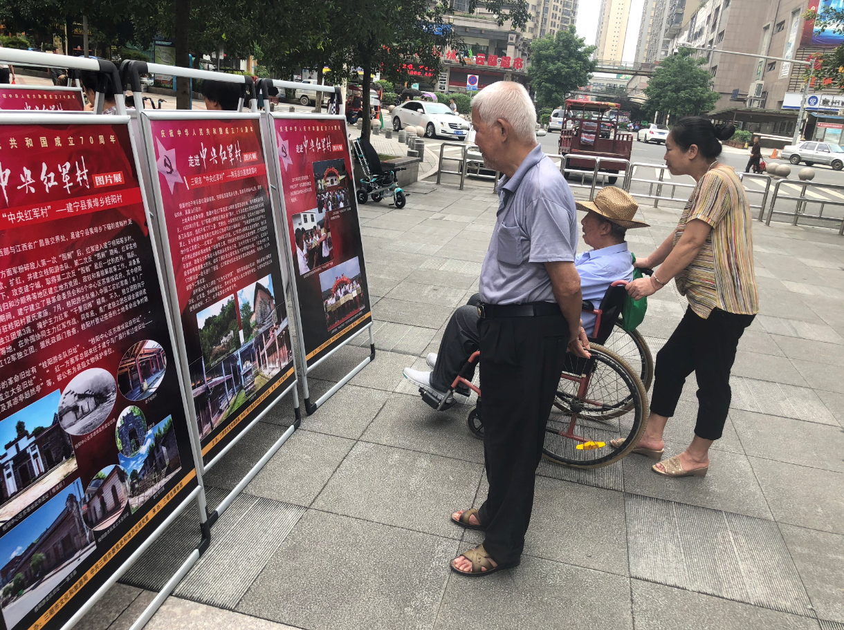 三明“中央红军村”图片展》在美地步行街展出